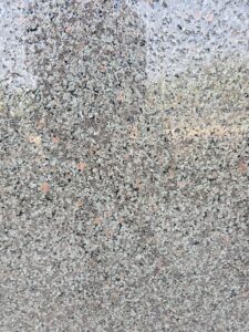 Close-up image of Apple Green Leather Finish Granite highlighting its fine-grained green, brown, and grey mineral pattern with rugged leather-texture detailing. Ideal for showcasing surface finish quality for interior and exterior stone applications.