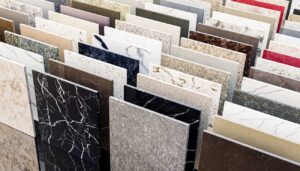 An entire landscape of polished stone panels rises in quiet formation, each slab carrying its own rhythm of veins, flecks, and mineral hues. From deep noir surfaces that feel almost cosmic to soft creams, earthy browns, bold marbles, and shimmering quartz patterns, this collection showcases the full vocabulary of modern surfaces. Here, designers and homeowners wander through possibilities, choosing the texture and tone that will anchor their spaces with character and permanence